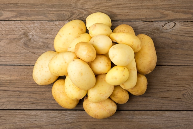 Jeunes pommes de terre sur une table en bois. Style rustique. Vue de dessus. Lay plat.