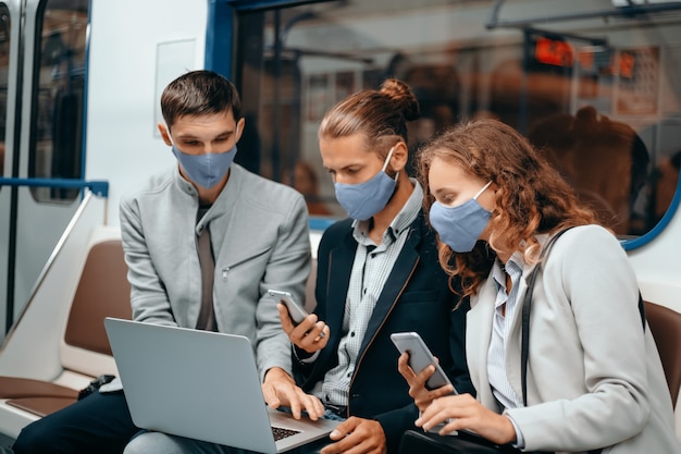 Jeunes portant des masques de protection assis dans le wagon de métro