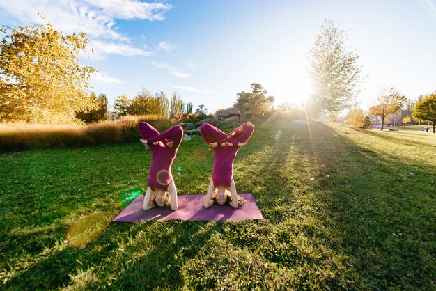 Jeunes pratiquants de yoga en groupe faisant du yoga sur la nature.