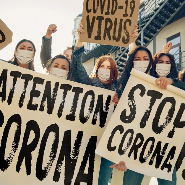 Photo les jeunes protestent contre la pandémie de coronavirus dans la rue. les femmes de race blanche ont une réunion sur le problème de la médecine, le système de santé, l'épidémie de danger. espace de copie. arrêtez le coronavirus, covid-19.