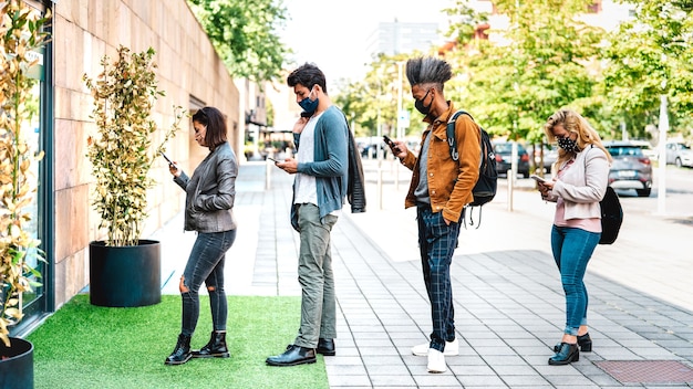 Les jeunes qui attendent en ligne pratiquant la distanciation sociale au magasin de la ville