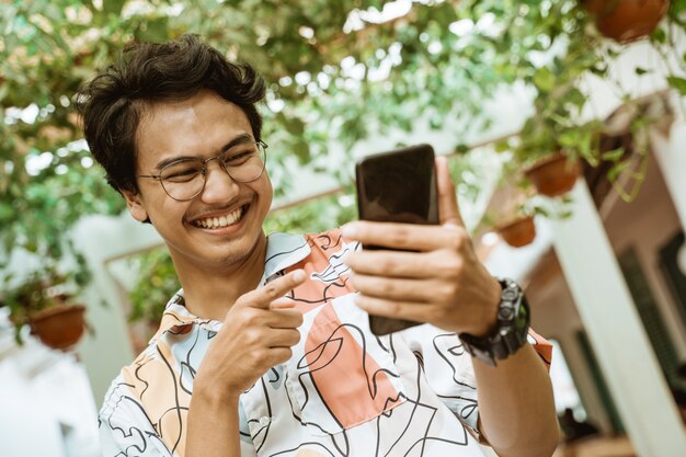 les jeunes rient tenant un téléphone portable