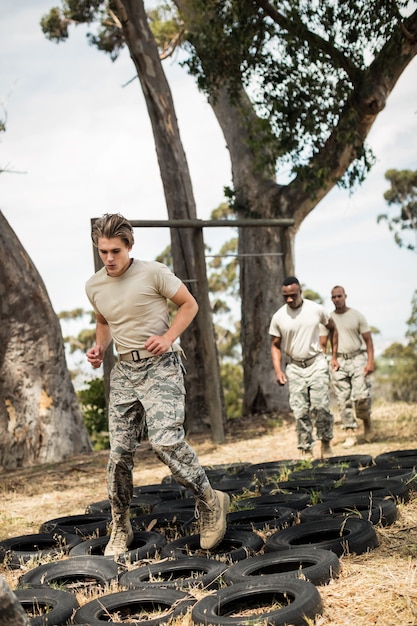 Les jeunes soldats militaires pratiquant la course d'obstacles de pneus