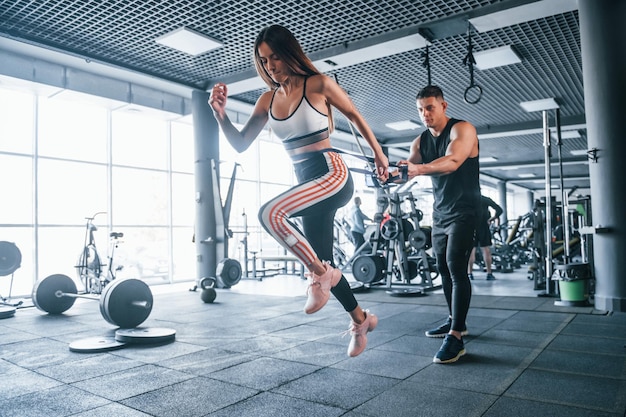 Jeunes sportifs faisant des exercices ensemble dans la salle de gym