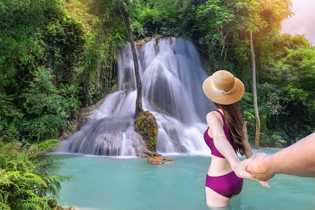 Photo de jeunes touristes asiatiques nagent à la cascade kaew mongkhon près de la cascade de kuang si