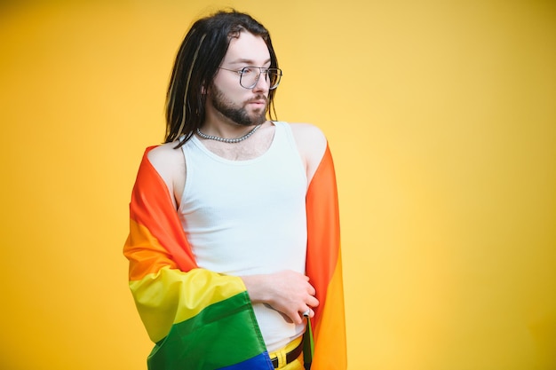 Jeunes transgenres LGBT avec drapeau arc-en-ciel sur l'épaule fond de couleur isolé expression de genre concept de fierté et d'égalité