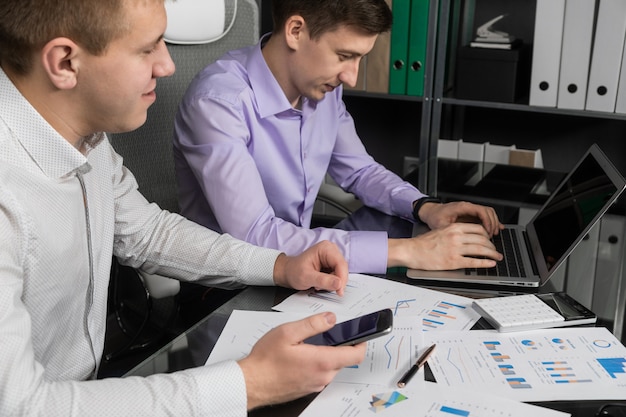 Les jeunes travaillent avec une calculatrice et un téléphone portable