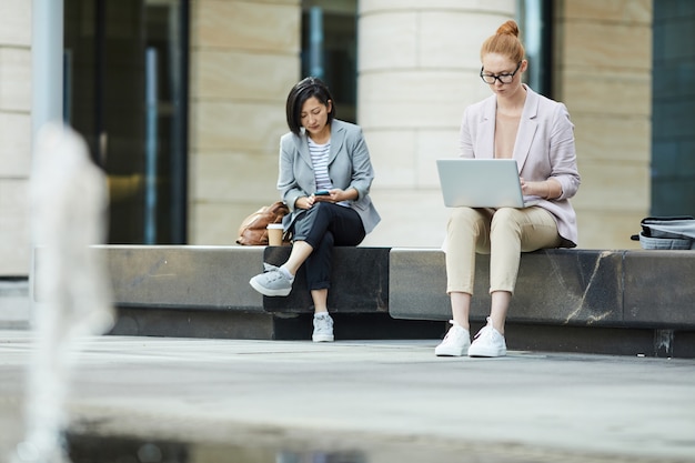 Jeunes utilisant des appareils mobiles à l'extérieur