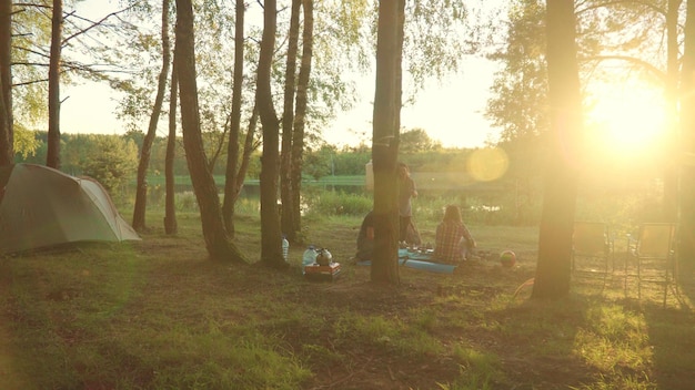 Photo les jeunes voyageurs profitent de vacances en camping assis le soir près des tentes