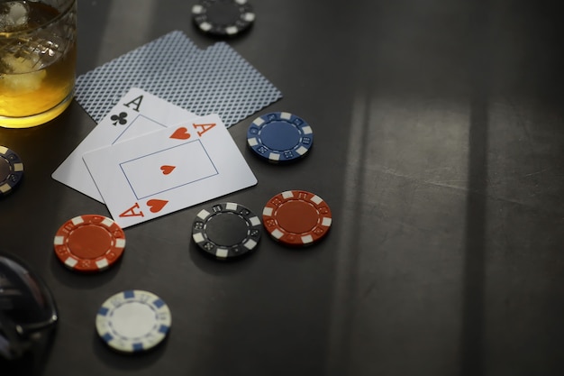Jeux de cartes pour de l'argent. Texas Hold'em Poker. Cartes en main, jetons à jouer, un jeu de cartes d'alcool dans un verre.