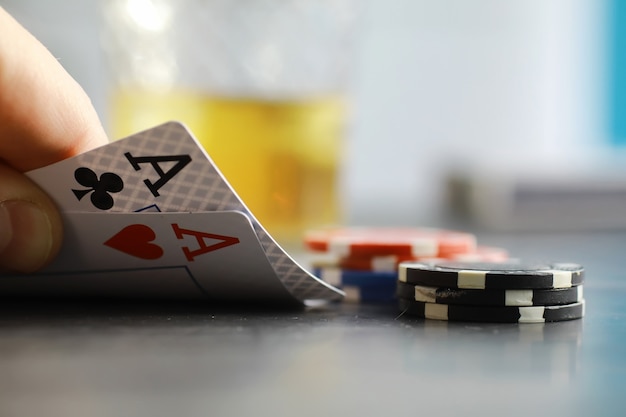 Jeux de cartes pour de l'argent. Texas Hold'em Poker. Cartes en main, jetons à jouer, un jeu de cartes d'alcool dans un verre.