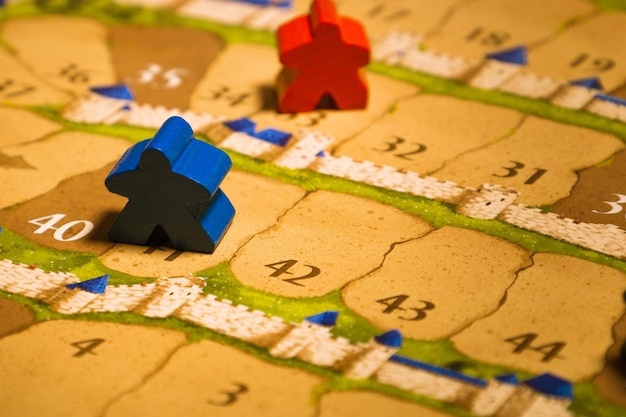 Photo jeux de société meeples debout sur la piste de score libre