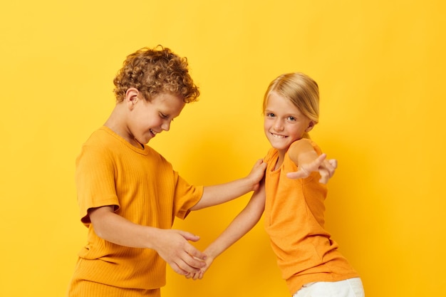 Jeux de vêtements décontractés pour garçons et filles s'amusant ensemble posant sur fond coloré