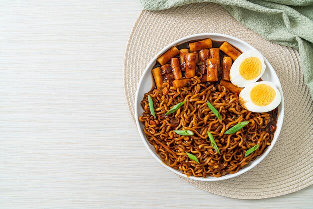 Jjajang Rabokki Nouilles instantanées coréennes ou Ramyeon avec gâteau de riz coréen ou Tteokbokki et œuf à la sauce aux haricots noirs