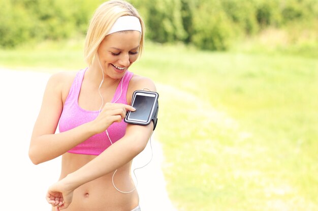 jogger écoutant de la musique via un smartphone dans le parc