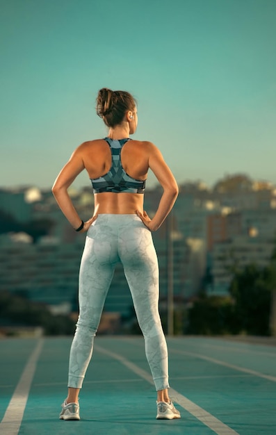 Jogging courir une femme athlétique forte se reposer avant de courir sur la piste en portant des vêtements de sport