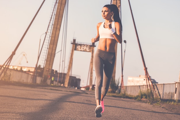 le jogging est sa vie. toute la longueur de la belle jeune femme en vêtements de sport