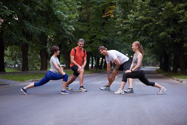 jogging groupe de personnes qui s'étend dans le parc avant l'entraînement