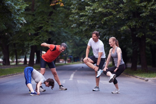 jogging groupe de personnes qui s'étend dans le parc avant l'entraînement