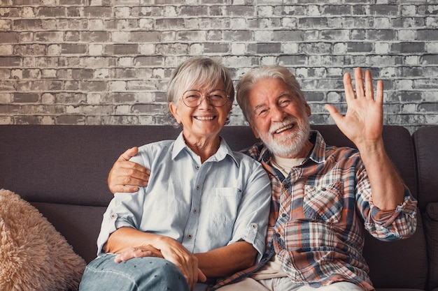 Joli et beau couple de personnes âgées souriant et regardant la caméra et parlant ensemble à la maison