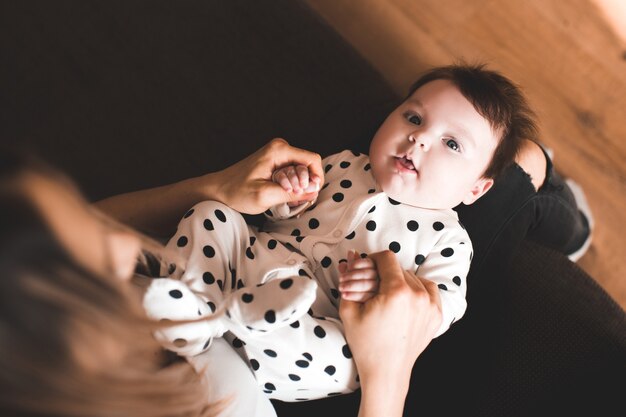 Joli bébé allongé sur les mains des mères