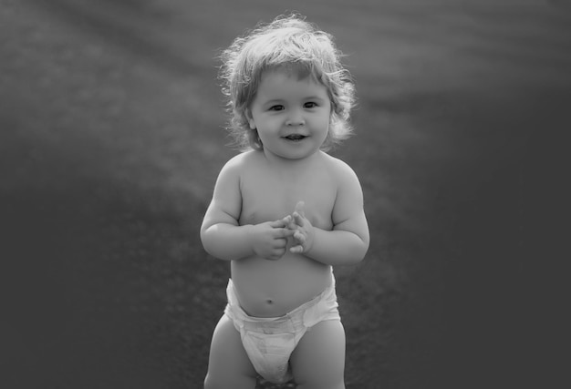 Joli bébé en couche sur l'herbe verte en été petit enfant drôle sur la nature heureuse enfance bébé et