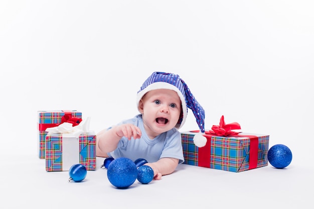 Joli bébé couché sur le ventre dans un bonnet du Nouvel An entre Noël