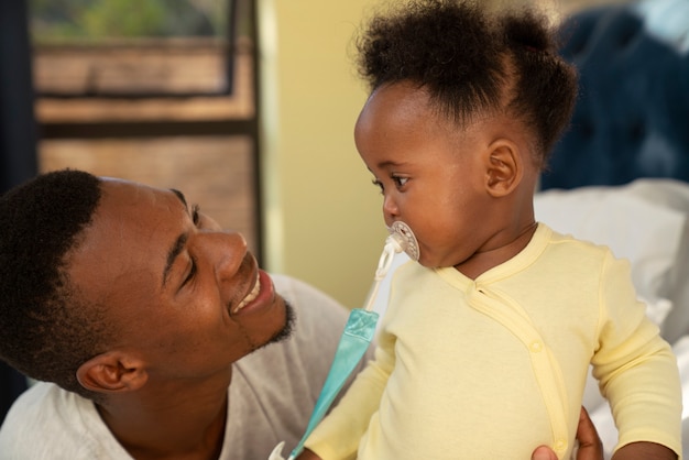 Joli bébé noir à la maison avec ses parents