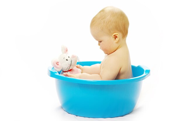Joli bébé prenant son bain sur blanc