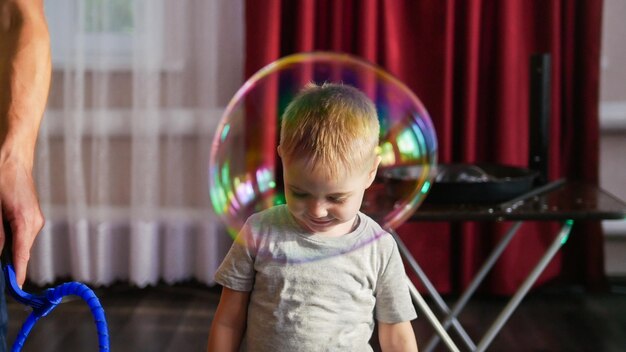 Joli bébé souriant avec une grosse bulle de savon