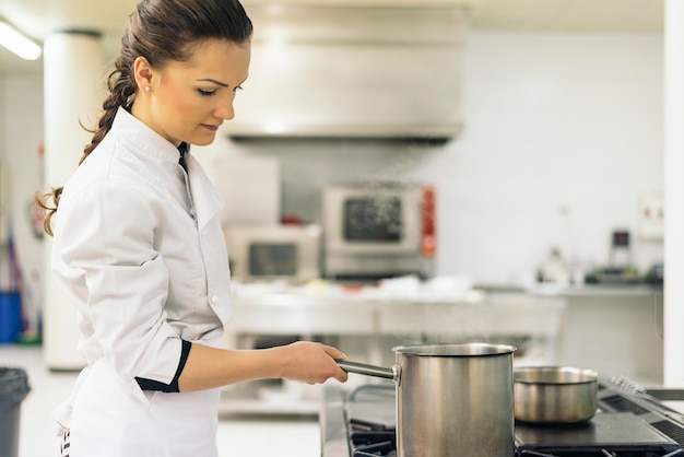 Joli chef professionnel cuisinant dans une cuisine.