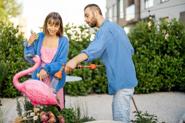 Joli couple arrosant des fleurs au jardin