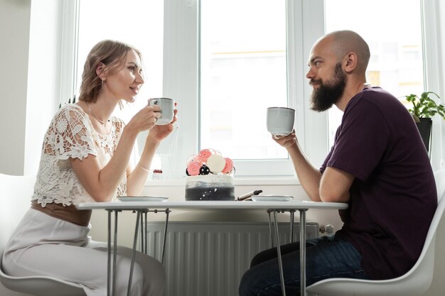 Joli couple boit du café ou du thé dans la cuisine Mari et femme passent du temps ensemble