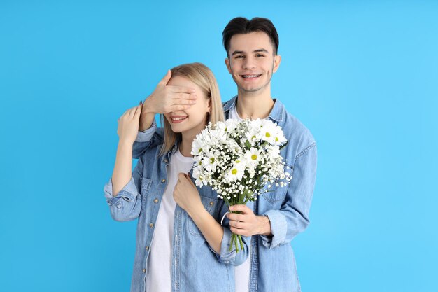 Joli couple avec bouquet sur fond bleu