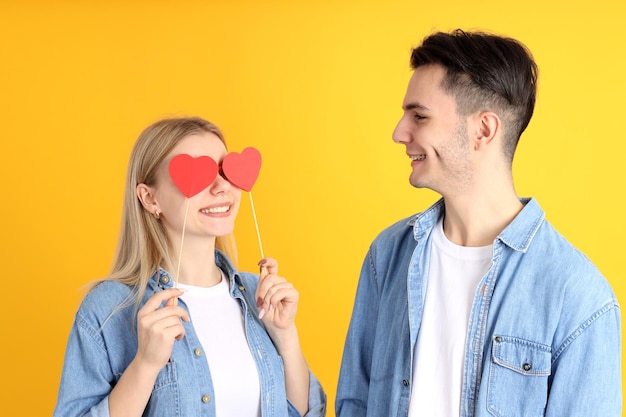 Joli couple avec des coeurs sur fond jaune