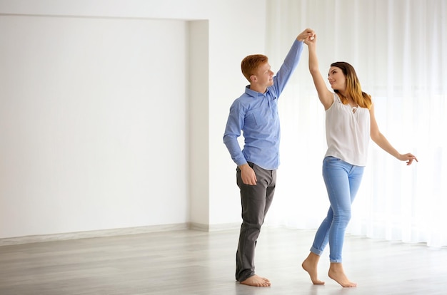 Joli couple dansant dans un nouvel appartement vide