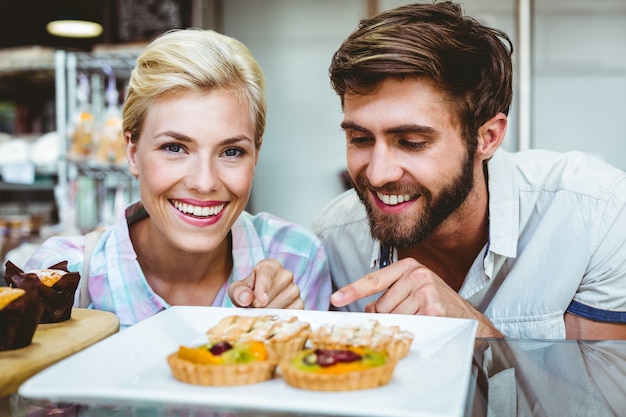 Joli couple sur une date pointant une tarte aux fruits