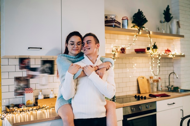 Joli couple étreignant dans la cuisine la veille de Noël