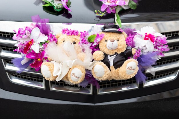 Joli couple ours en peluche en costume décoré sur la voiture de mariage
