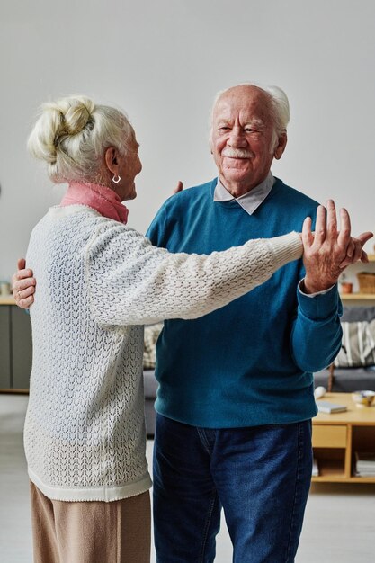 Joli couple de personnes âgées apprenant à danser ensemble pendant la leçon