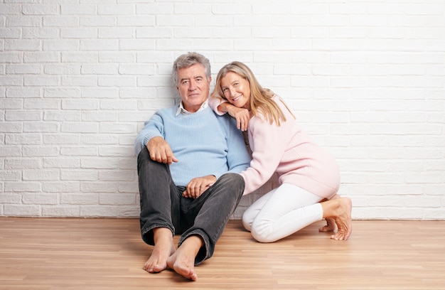 Joli couple de personnes âgées assis sur le sol de leur maison. concept de l&#39;amour