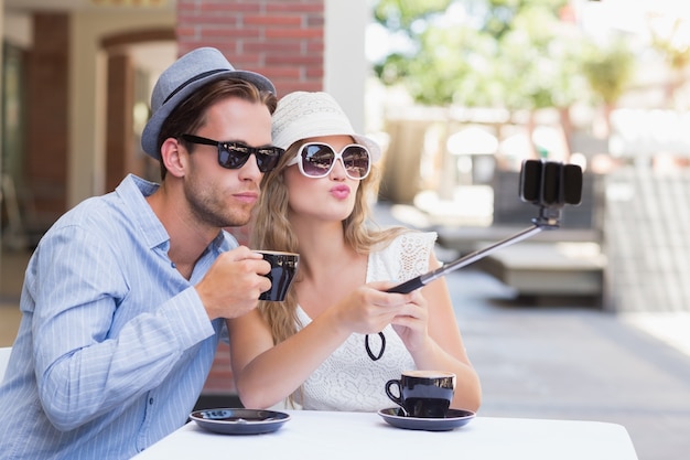 Joli couple prenant un selfie avec un bâton de selfie