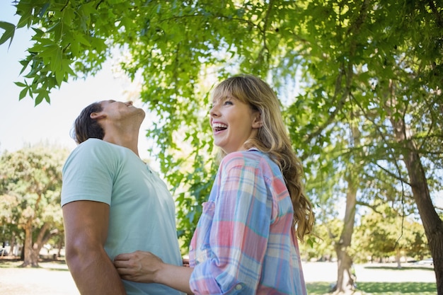 Joli couple en riant et étreindre dans le parc