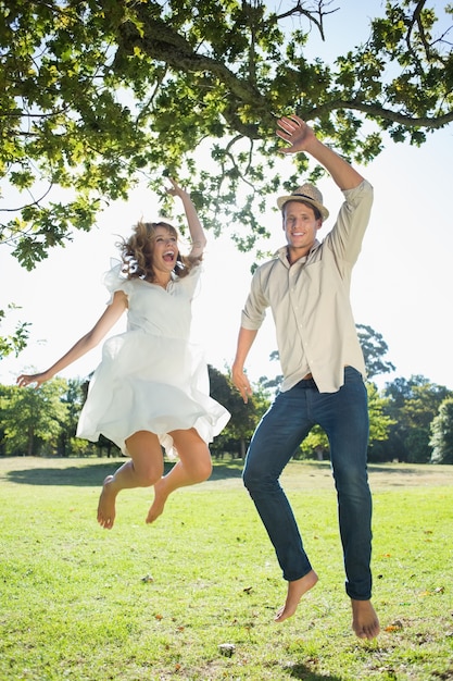 Joli couple sautant dans le parc ensemble