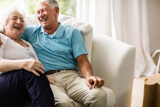 Joli couple senior embrassant sur le canapé