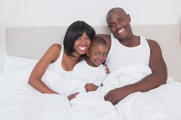 Joli couple avec son fils au lit ensemble