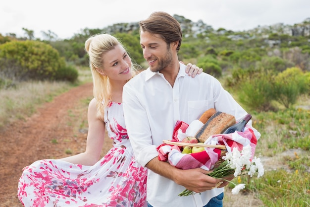 Joli couple va pour un pique-nique en souriant les uns aux autres