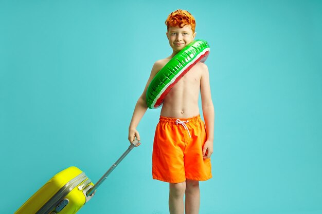 Joli enfant rougis voyageur touriste garçon en été orange tronc de natation cercle gonflable