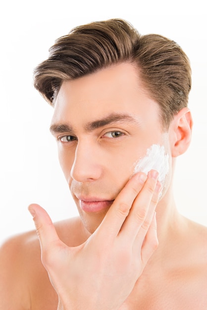 joli homme enduisant de mousse sur son visage