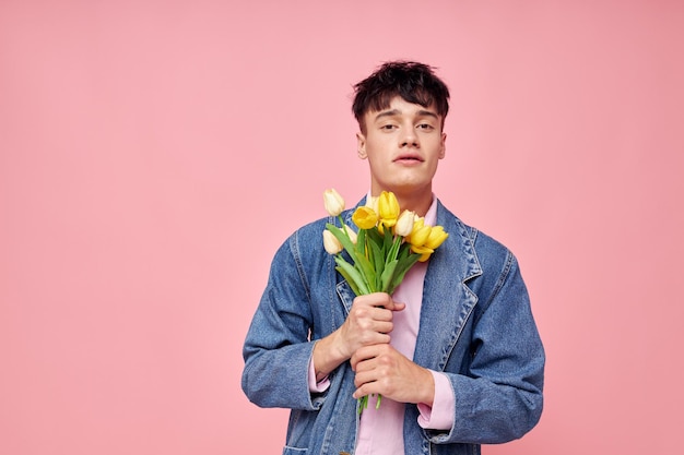 Joli homme romance date bouquet de fleurs posant fond rose inchangé